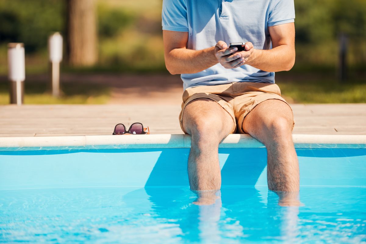 homme controlant sa piscine avec son mobile